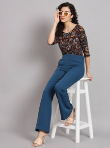 Floral cotton top in brown, styled with blue pants and accessories.