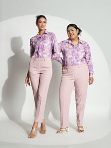 Two models wearing baby pink mid-waist trousers styled with matching tops.