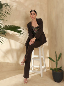 Lapel-less chocolate brown stretch pant suit styled with floral top.