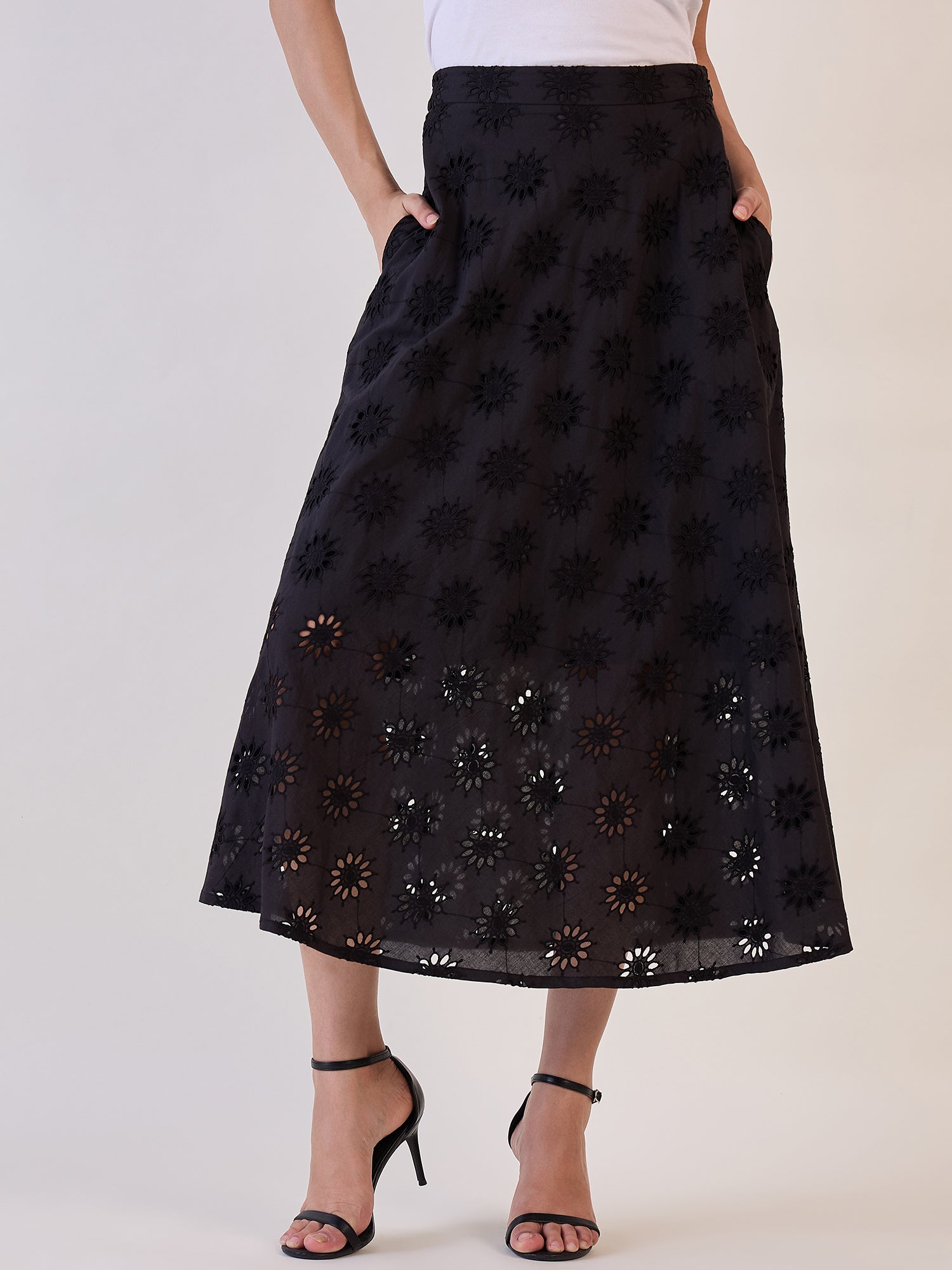 Black Schiffli flared skirt with floral embroidery and pockets.