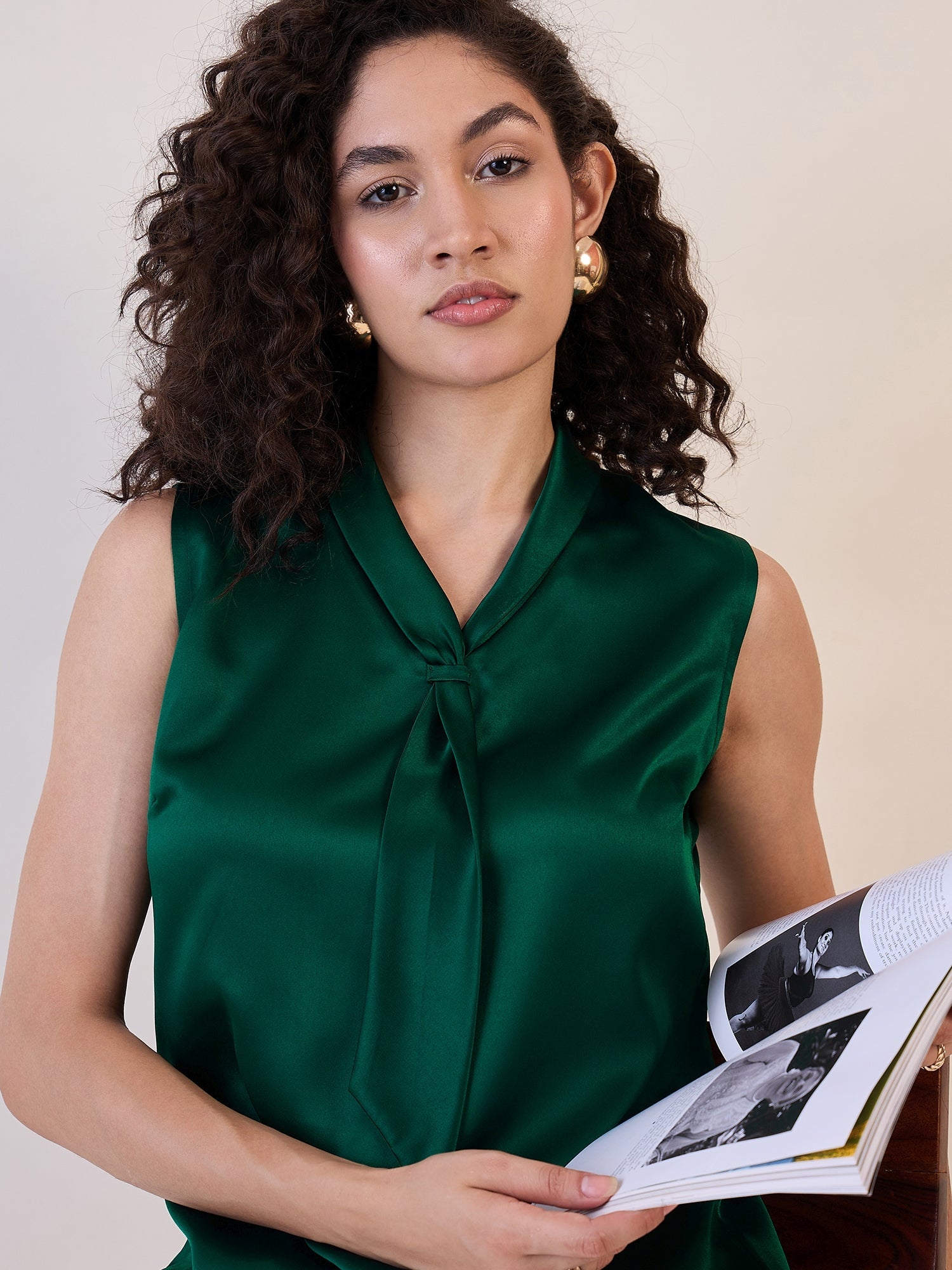 Green satin tie collar neck top on a model holding a book.