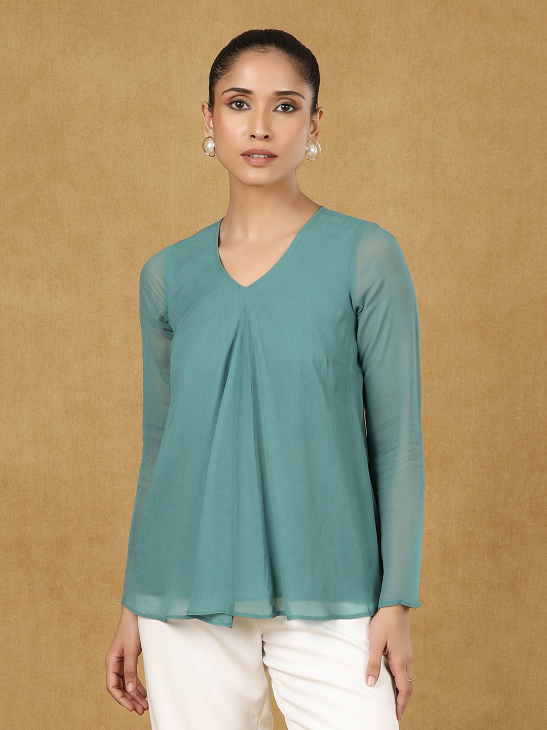 Green A-line top on model with elegant styling.