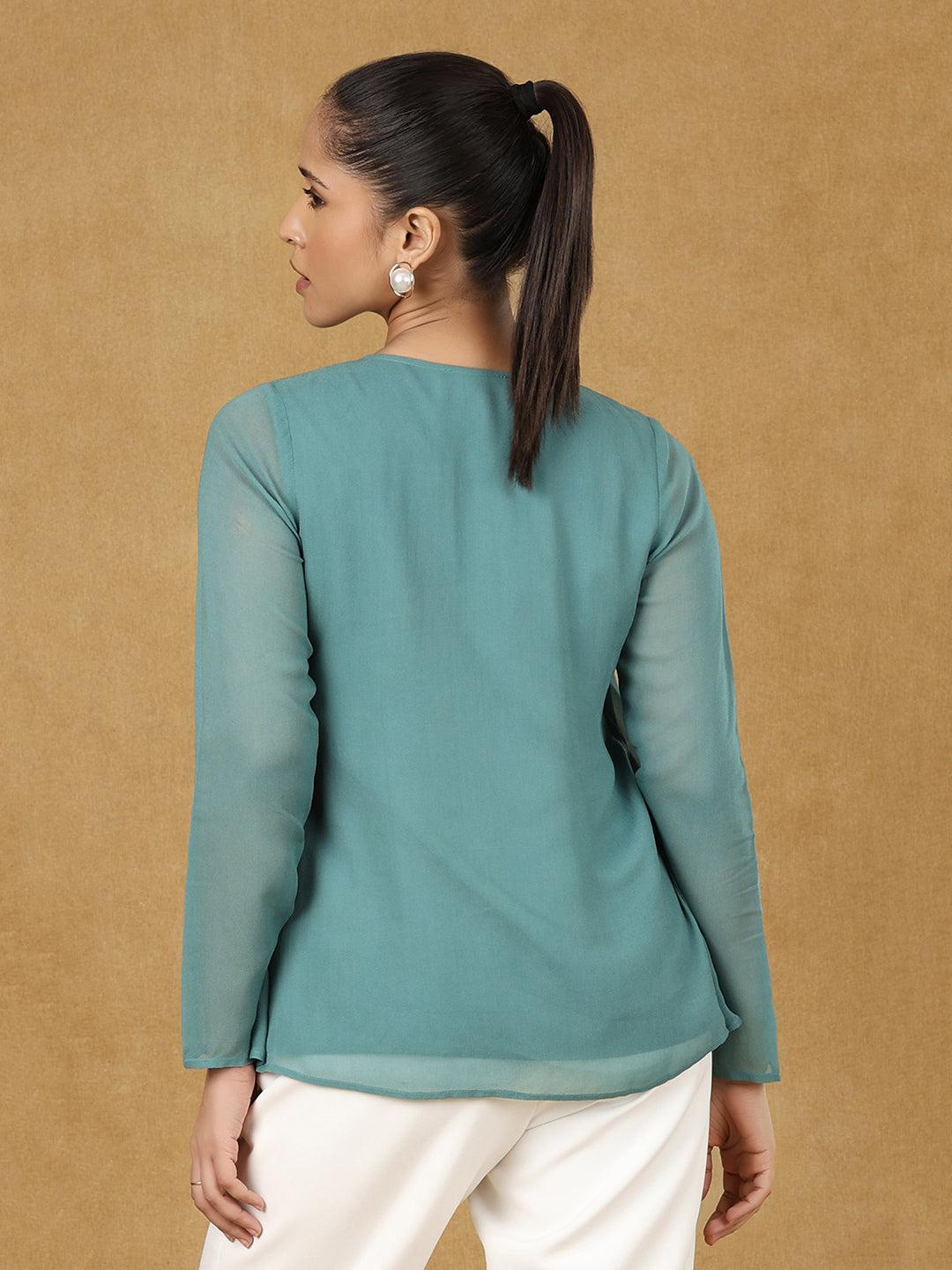 Back view of a woman wearing a green A-line top.