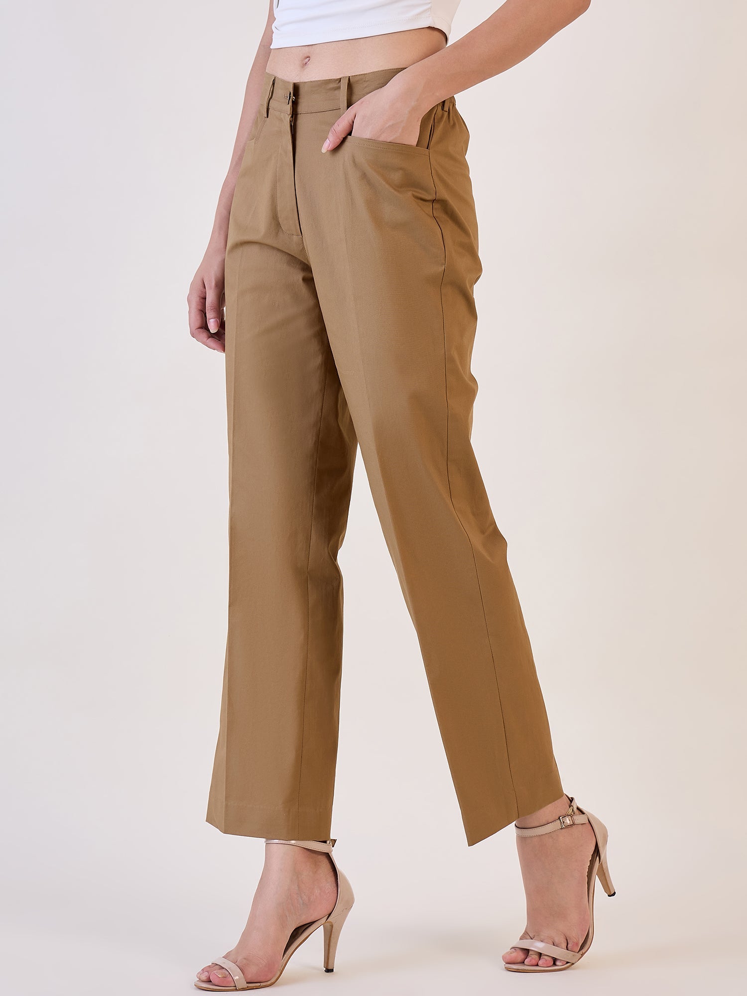 Brown straight fit mid waist trouser displayed on model with stylish heels.