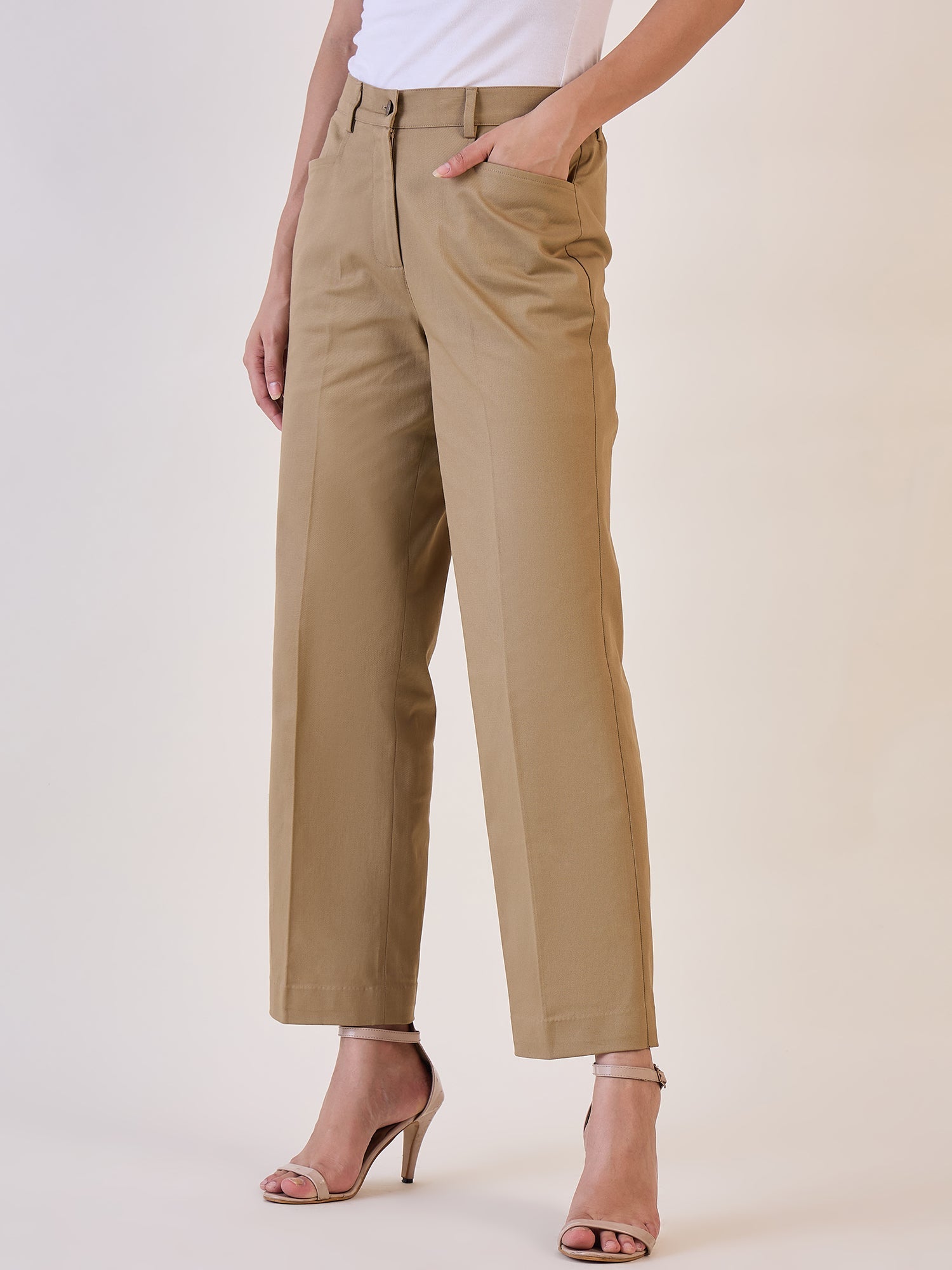 Straight fit mid waist trouser in camel brown worn with stylish heels.