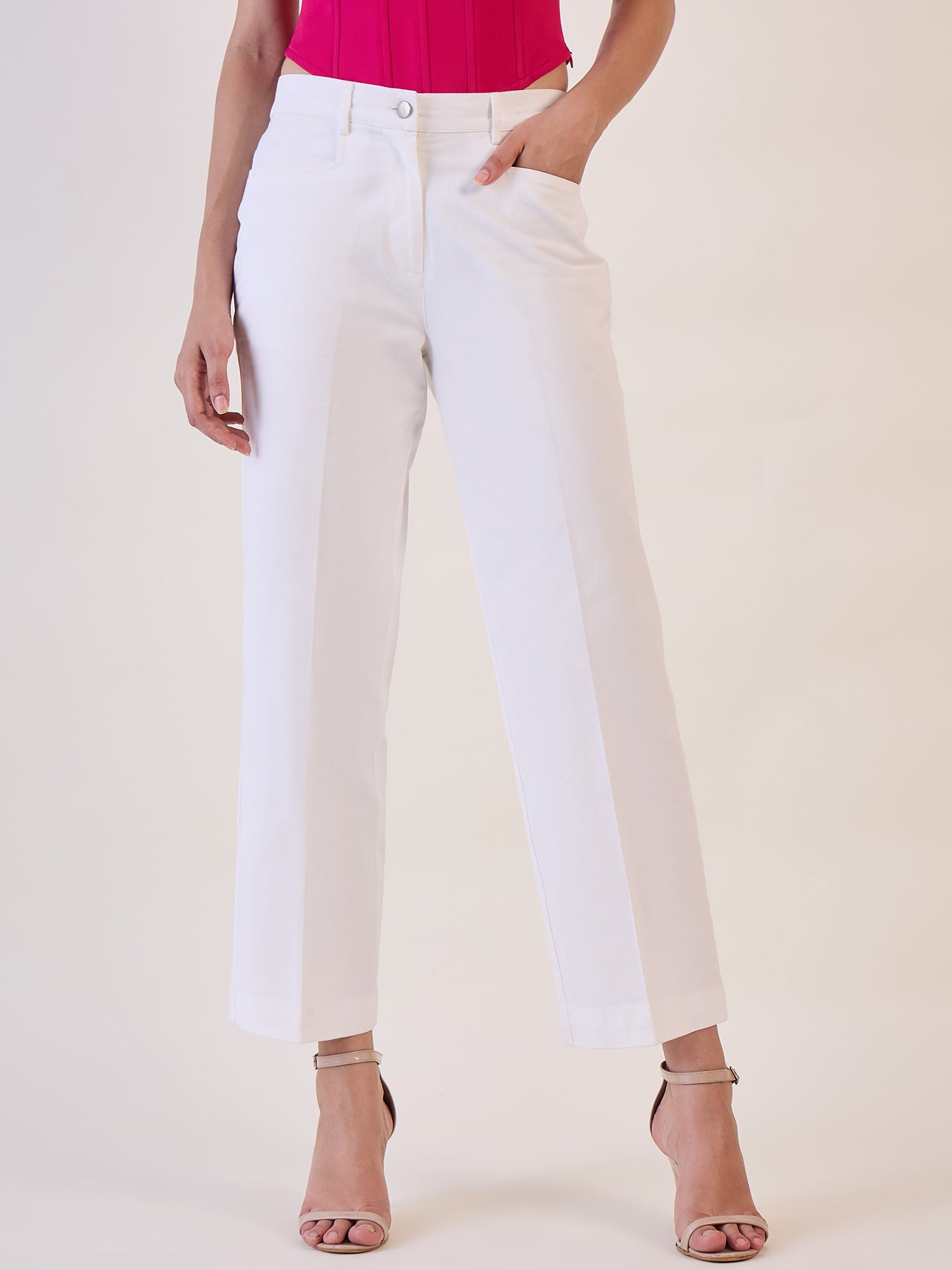 White straight fit mid waist trouser paired with a pink top.