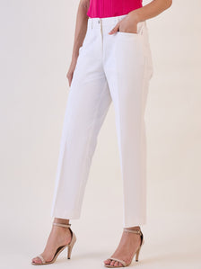 White straight fit mid waist trousers styled with a pink top and heels.