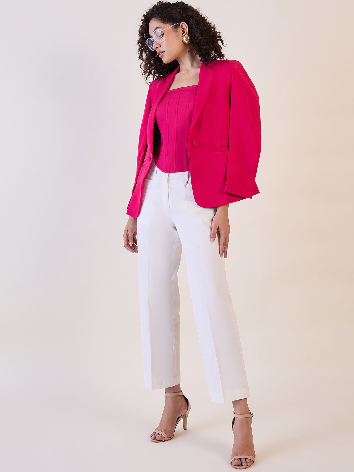 Model wearing white straight fit mid waist trousers with pink blazer.